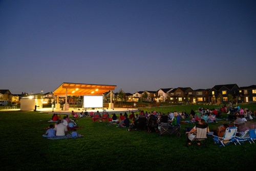 A large movie screen lights up a summer night at Reed’s Crossing Park.