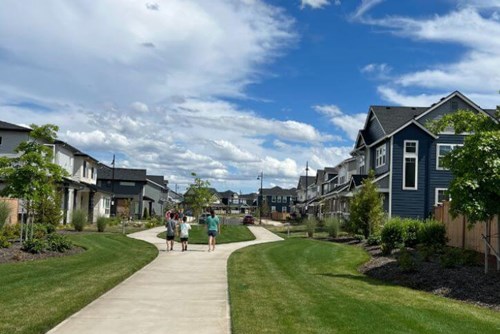 Three children walking down community path surrounded by new construction.