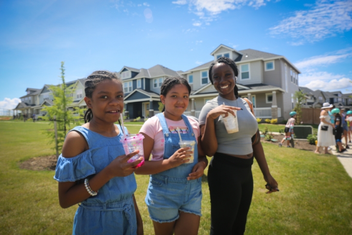 Three girls hold iced drinks in Tamarack Park on a sunny day in Hillsboro, Oregon.