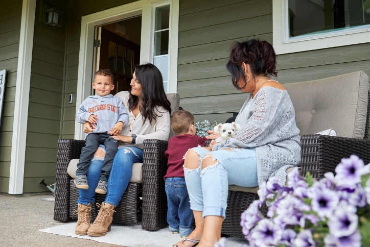 Two women, two small children, and a tiny white dog sitting on a porch in Hillsboro, Oregon.