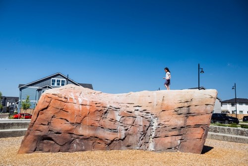 A girl climbs in the boulder garden in Hillsboro’s Reed’s Crossing Park.