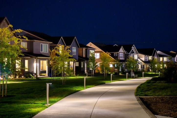 Nighttime photo of Reed’s Crossing Park in Hillsboro, OR shows a brightly lit walking path in front of a row of homes.